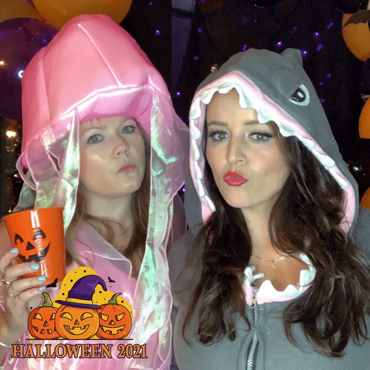 Guests posing for a looping Boomerang GIF with a custom Halloween pumpkin overlay at a Selfie Spot booth