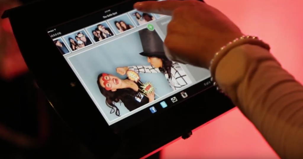 Guest using a Selfie Spot photo booth sharing station kiosk to post pictures